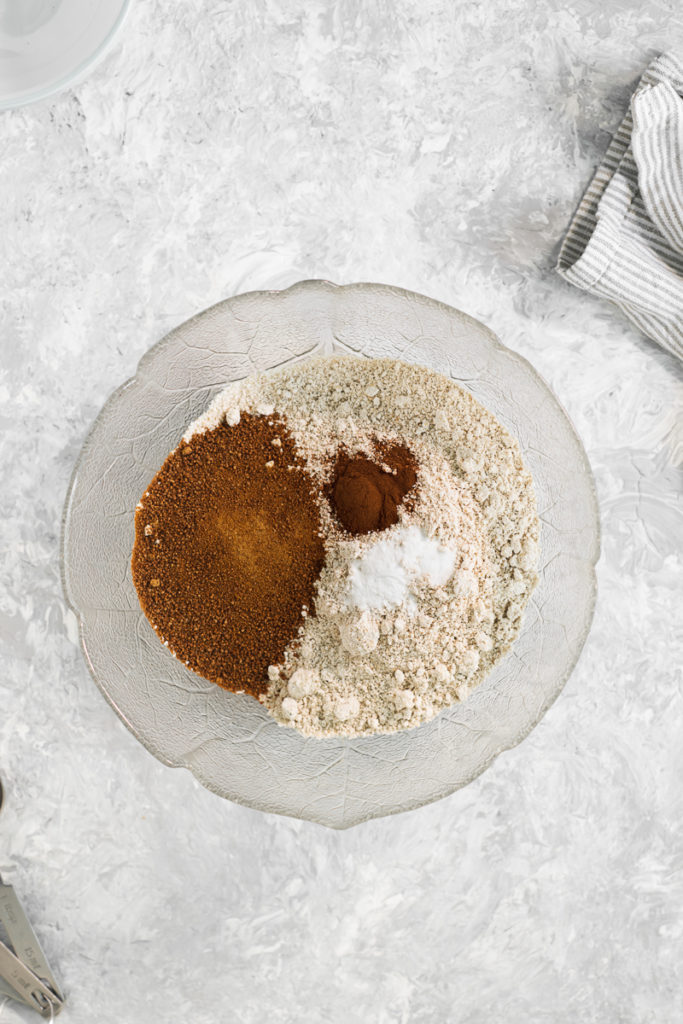 A mixing bowl with flour, coconut sugar, cinnamon and baking soda.