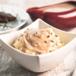Vegan Mushroom Gravy on top of a bowl of mashed potatoes, topped with dried chives.