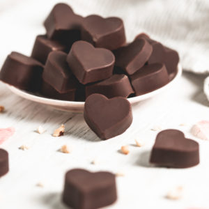 An overflowing plate of heart-shaped chocolate hazelnut truffles.