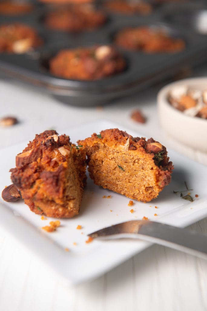 A sweet potato muffin sliced in half, baring a fluffy centre.