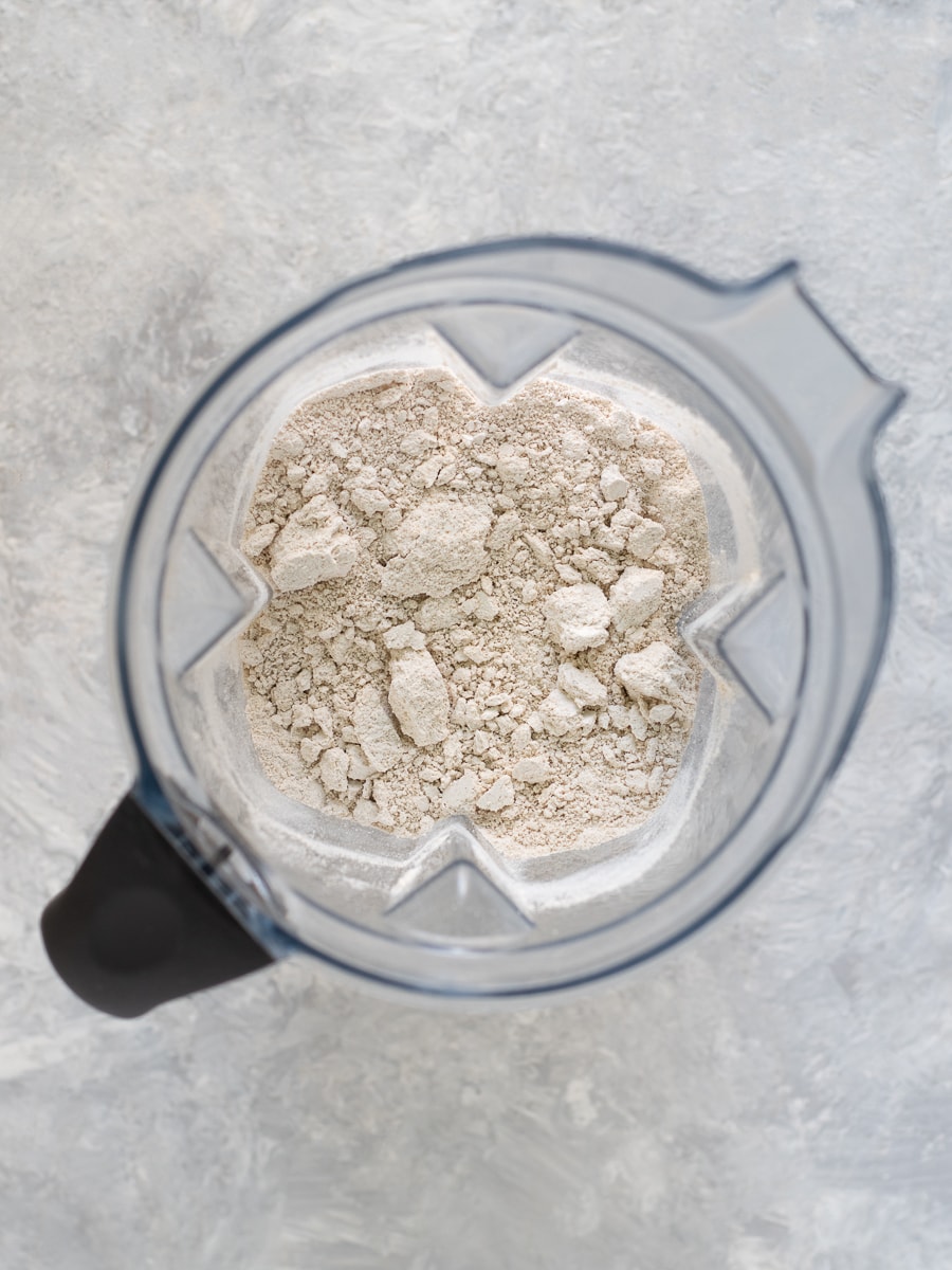 A blender jug holding a batch of freshly ground oat flour.