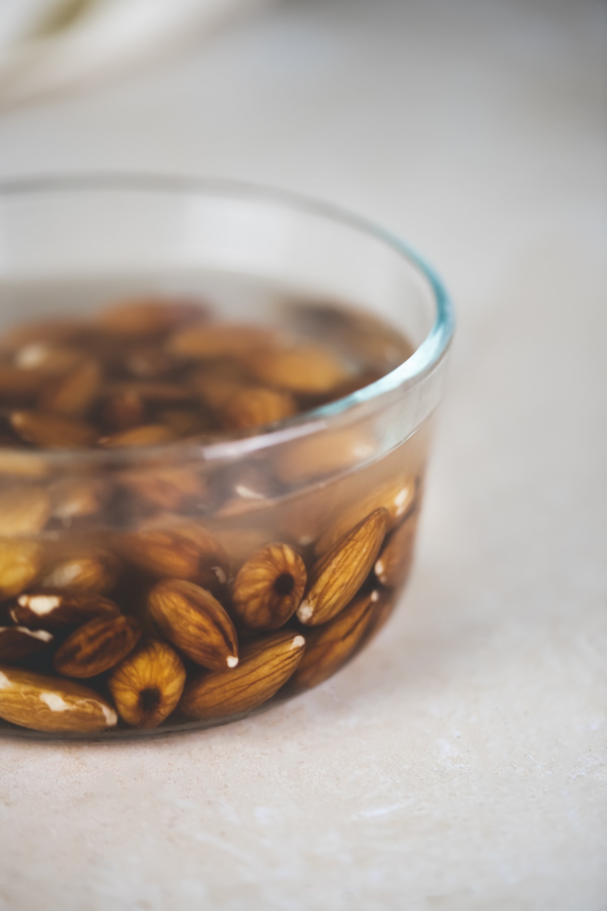 Almonds soaking in a glass bowl.