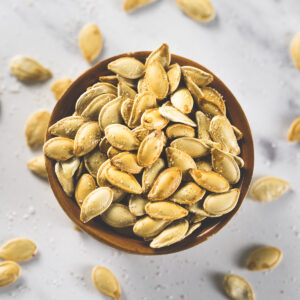 An overflowing bowl of perfectly roasted, golden-brown pumpkin seeds.