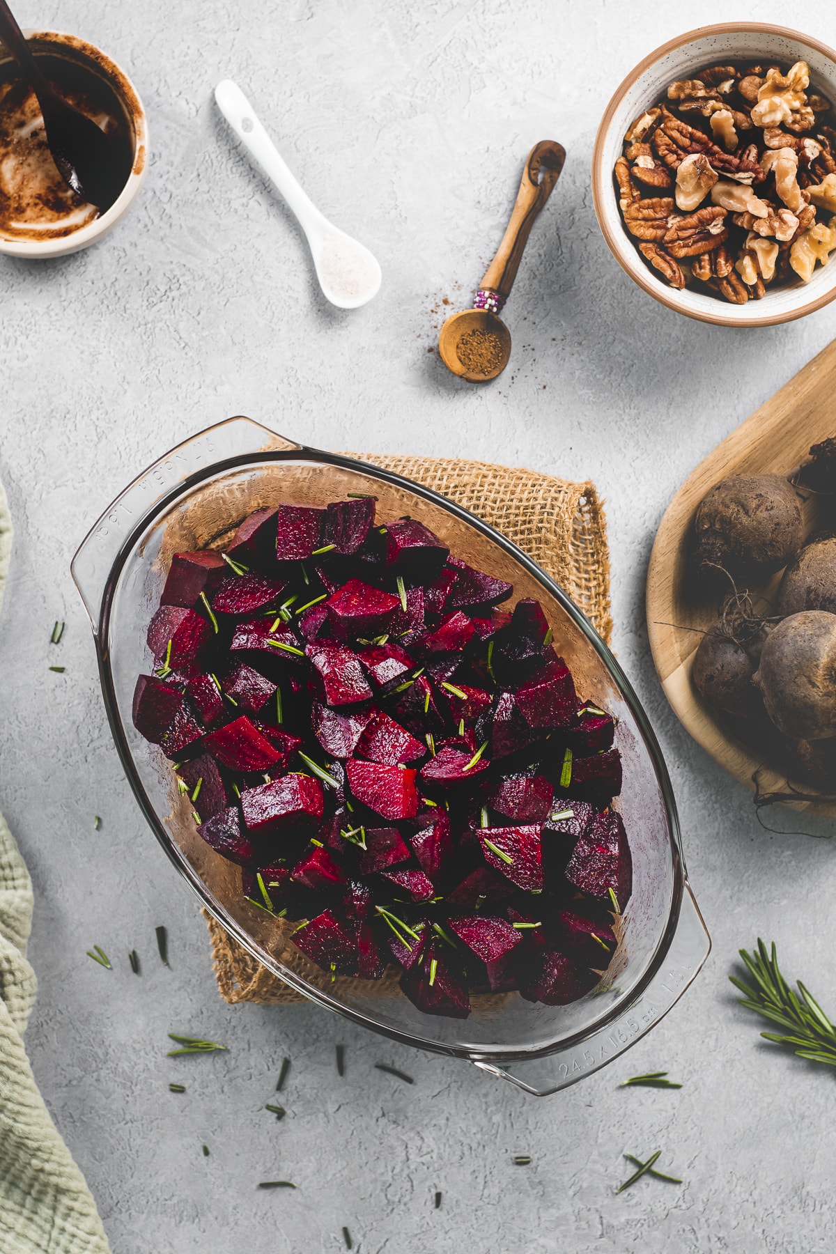 A glass roasting dish full of Roasted Balsamic Glazed Beets topped with fresh rosemary.