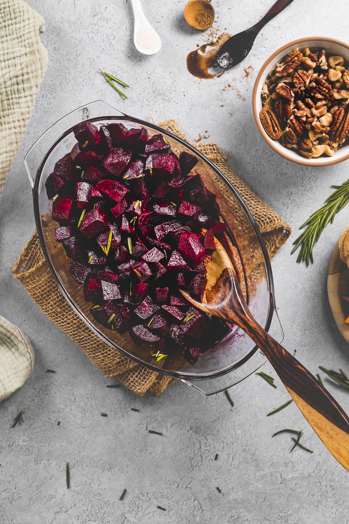 A roasting dish with baked balsamic glazed beets topped with fresh rosemary.
