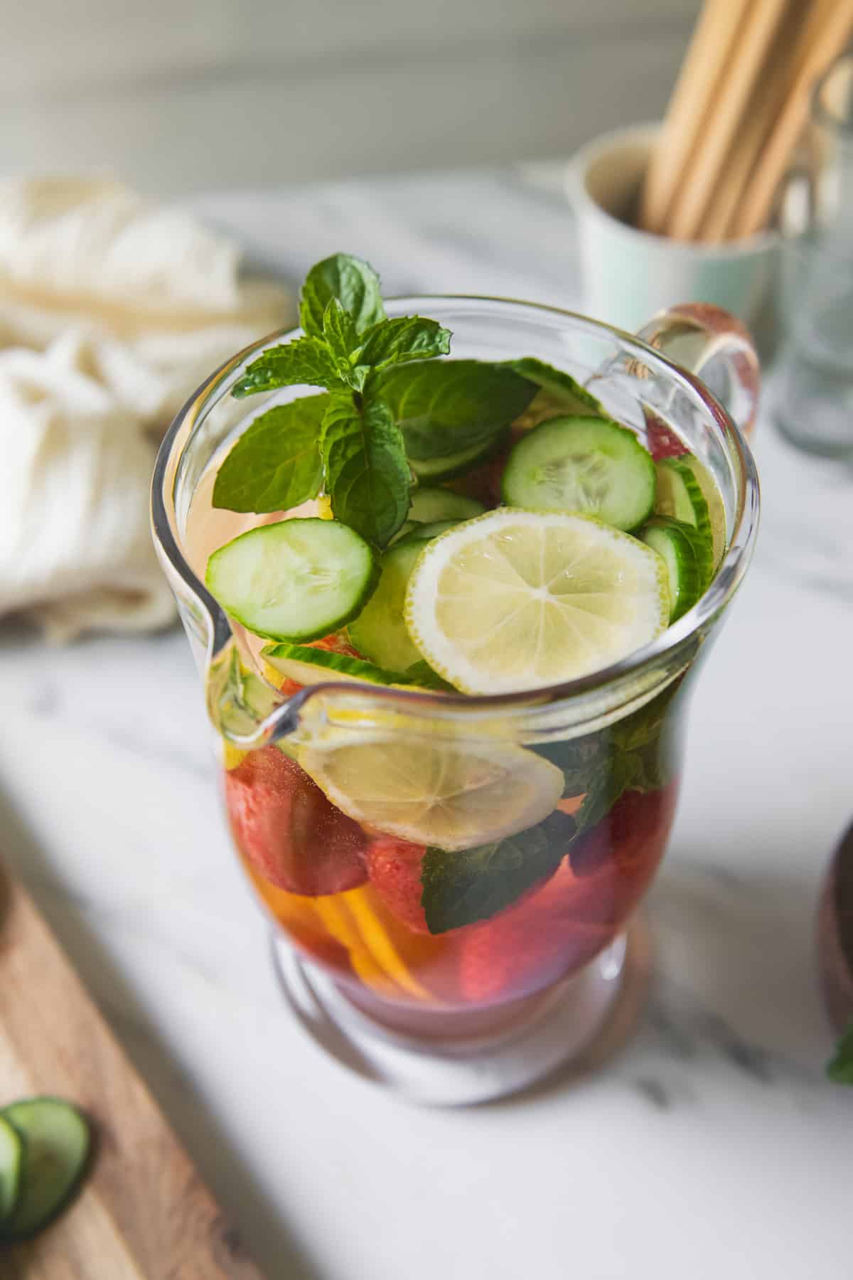 A pitcher of water infused with lemon, cucumber, strawberries and mint.