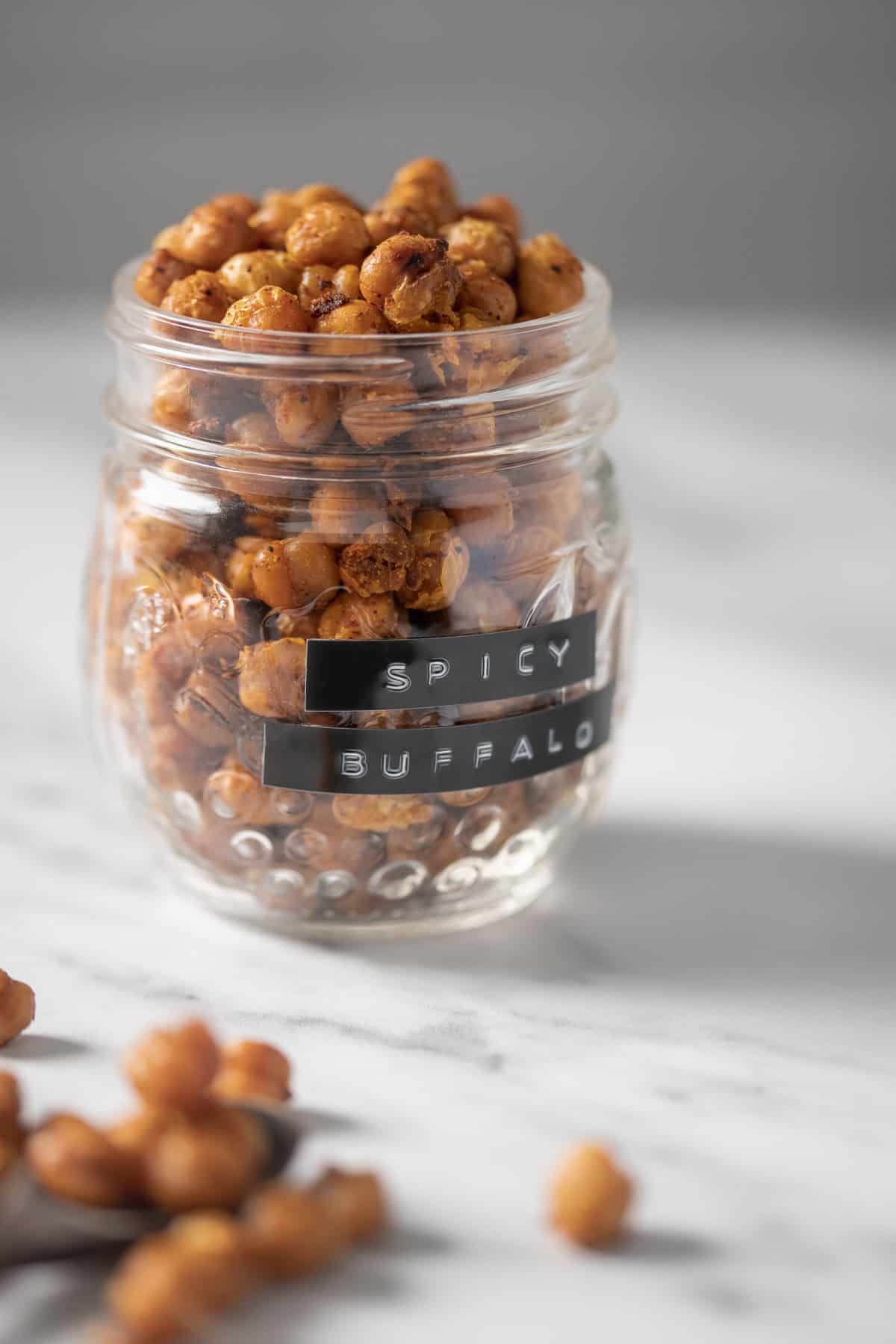A jar labelled "spicy buffalo" filled with seasoned, roasted chickpeas.