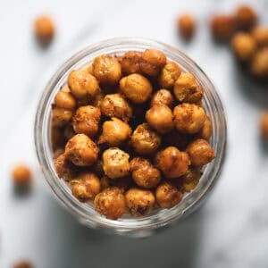 An overflowing jar of roasted and seasoned chickpeas.