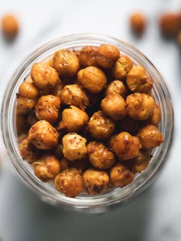 An overflowing jar of roasted and seasoned chickpeas.