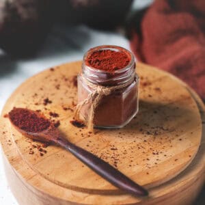 Freshly blended beetroot powder filled to the top of a jar and spilled all around.