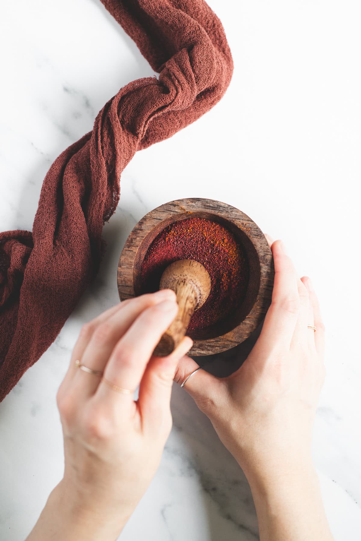 Dried Beetroot being crushed into a powder with a mortar and pestle.