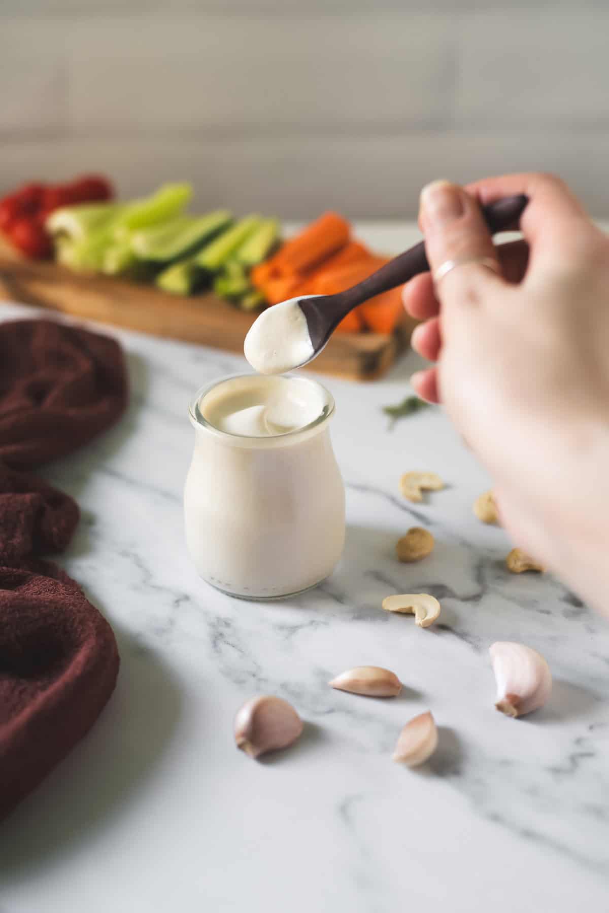 Garlic cream sauce swirled in a jar with a spoon being dipped in.