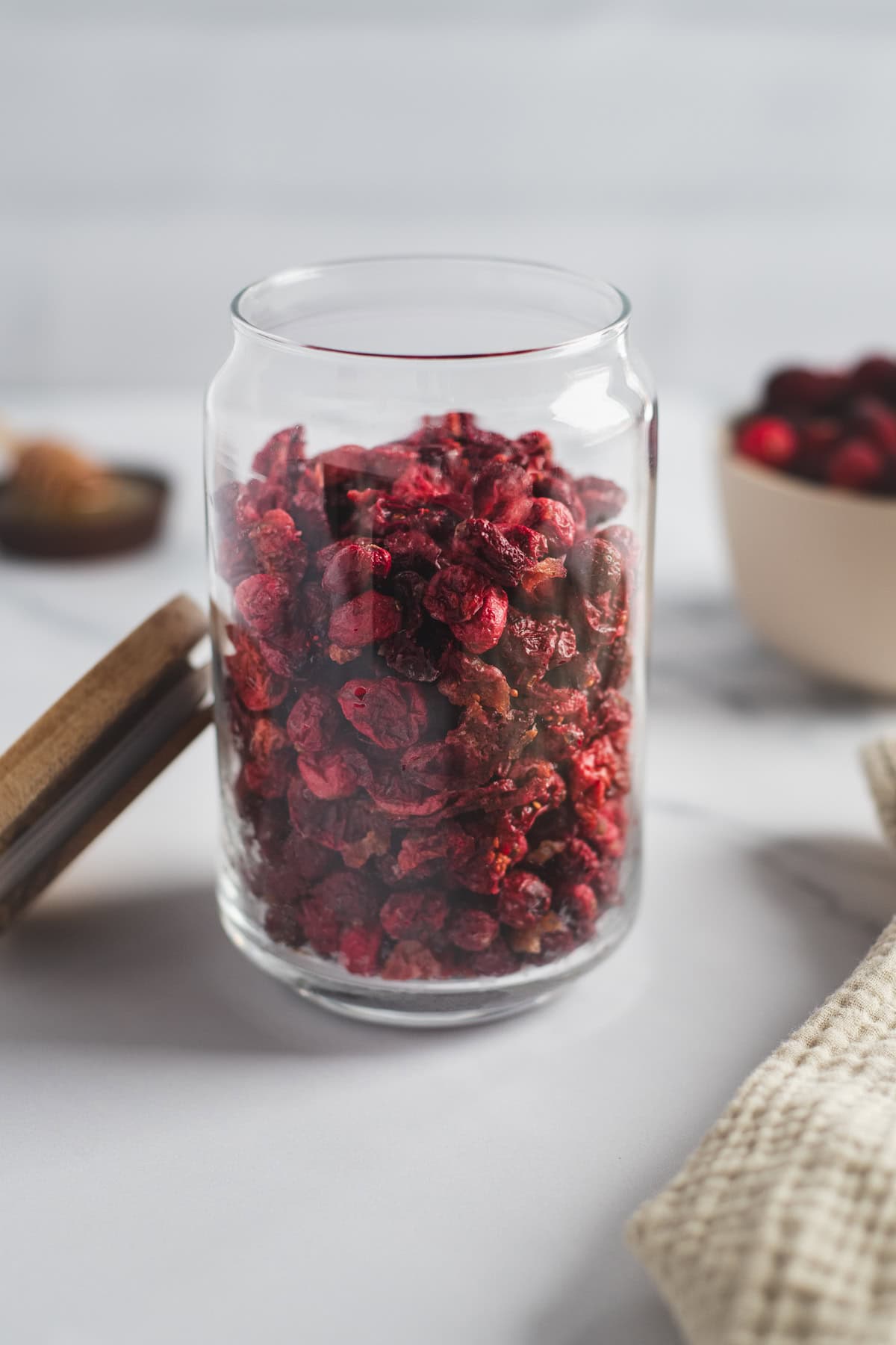 A glass jar filled with dried cranberries.