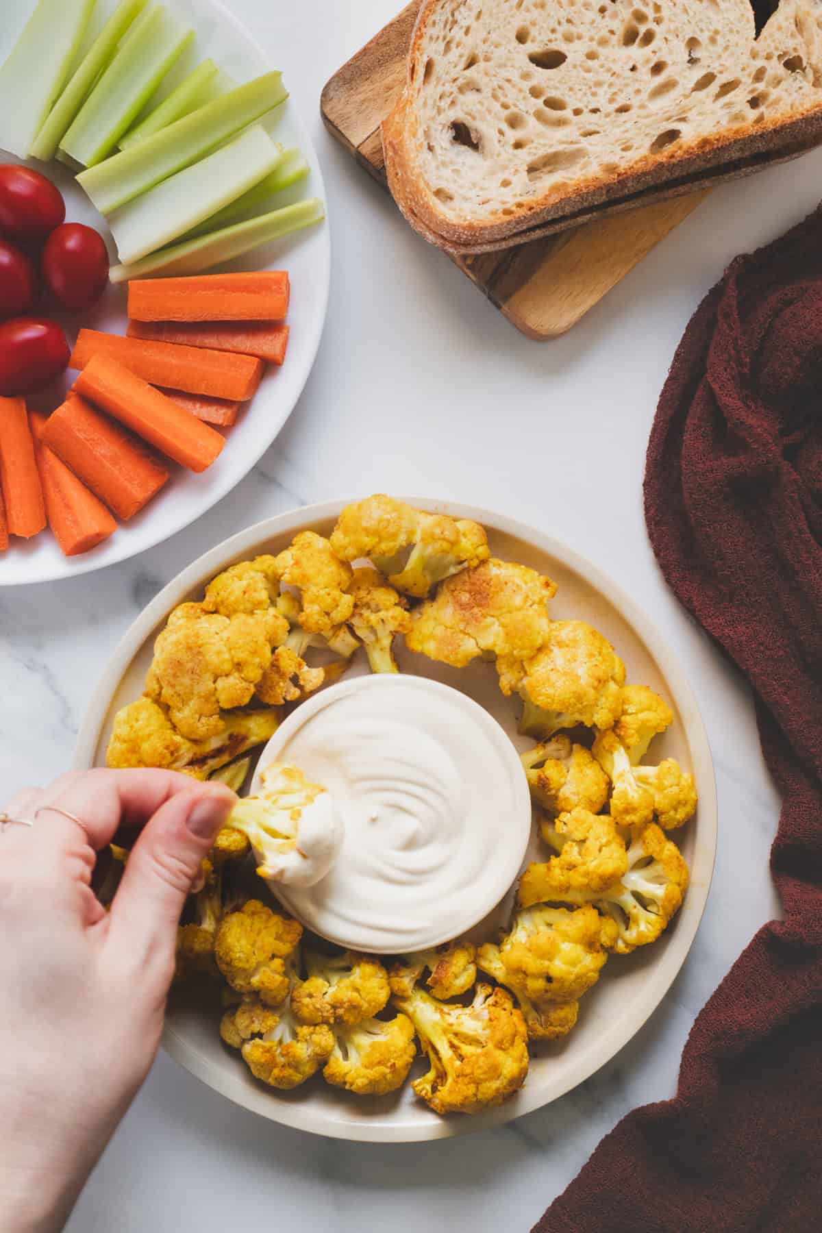 A spiced flourless cauliflower bite being dipped in a bowl of creamy sauce.