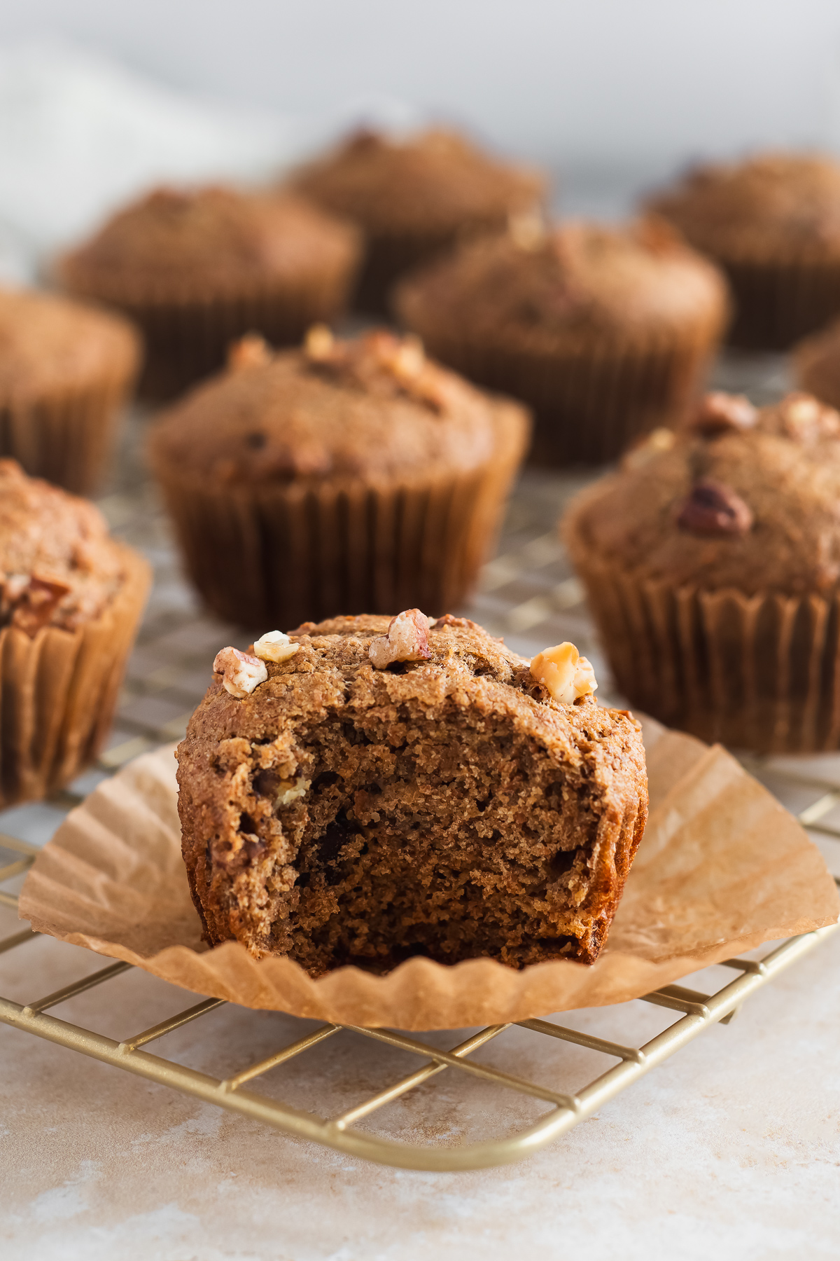A bite taken out of a fluffy banana nut muffin.