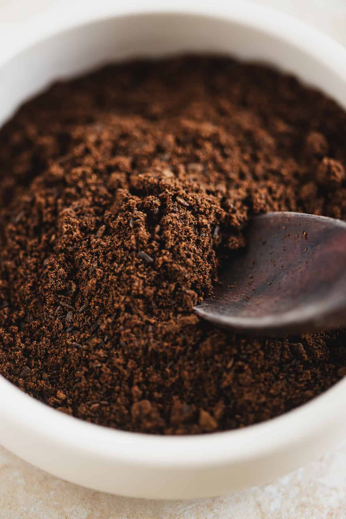 Finely ground vanilla bean powder in a bowl with a spoon.