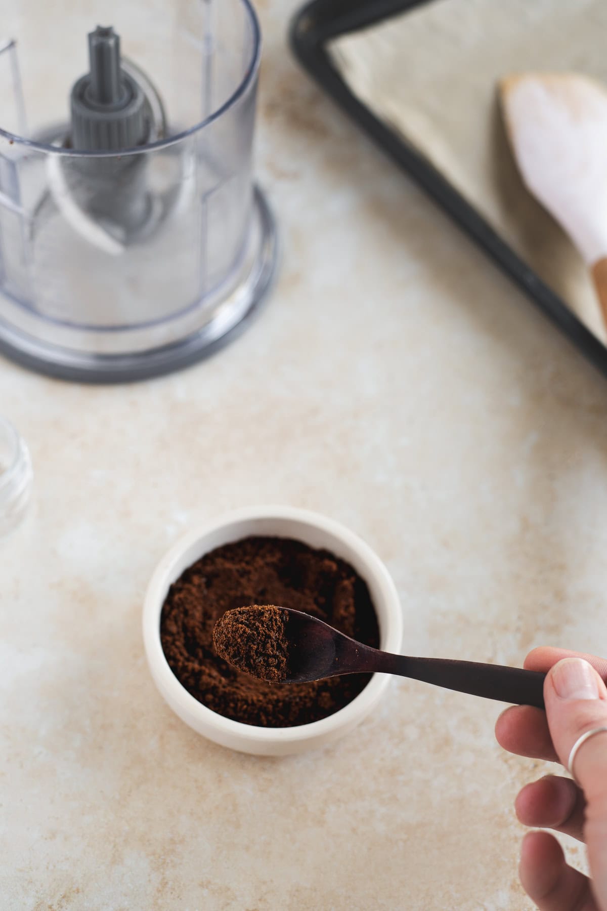 Michelle lifting a spoonful of vanilla bean powder out of a bowl.