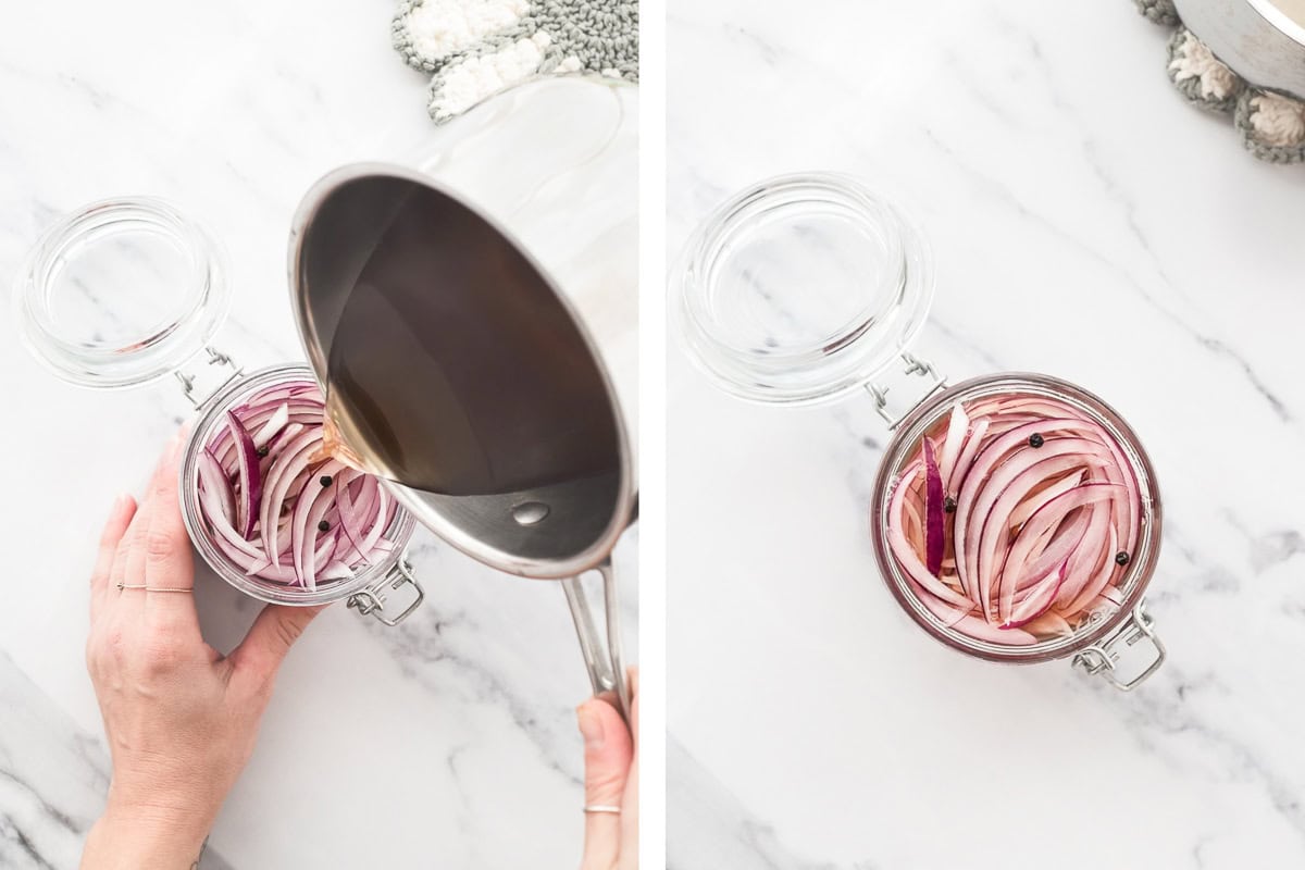 Brine pouring from a stainless steel pot into a glass jar over sliced red onion and whole peppercorns.